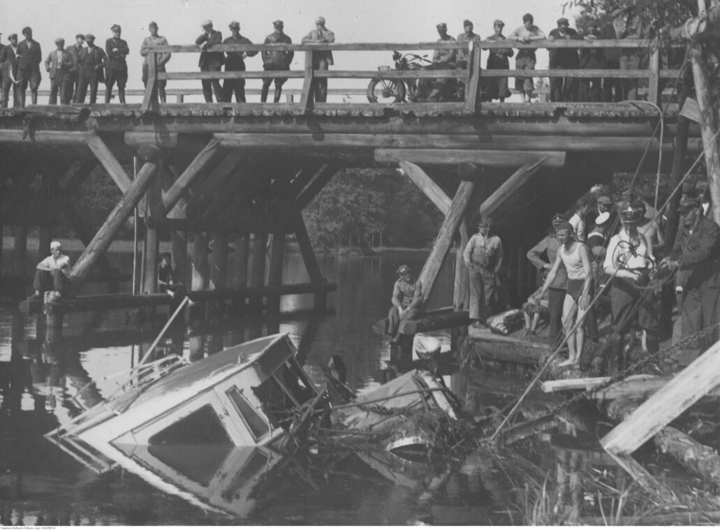 Stan dróg na Mazowszu był dramatyczny. Na zdjęciu z 1934 r. wydobywanie z wody autobusu jadącego z Warszawy do Łomży, który spadł z drewnianego mostu. Fot. NAC