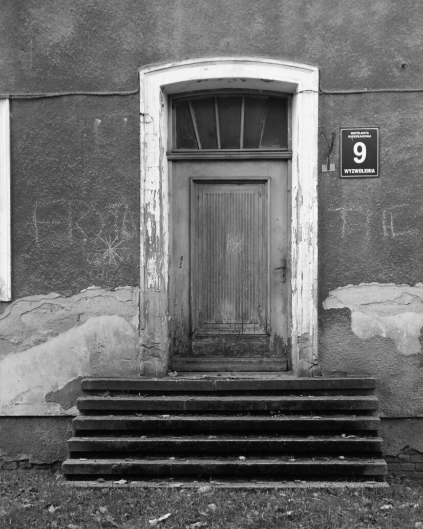 Ciechanów. Wyzwolenia 9. Zamknięty łukiem odcinkowym portal drzwi na klatkę schodową w bloku wielorodzinnym. Fot. Jerzy S. Majewski
