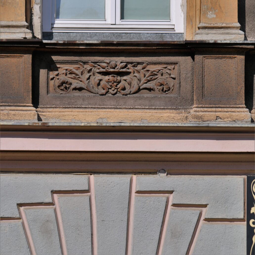 Radom. Pl. Konstytucji 5. Płyciny w fasadzie pod oknami pierwszego piętra wypełniają powtarzające się dekoracje sztukatorskie. Fot. Jerzy S. Majewski 